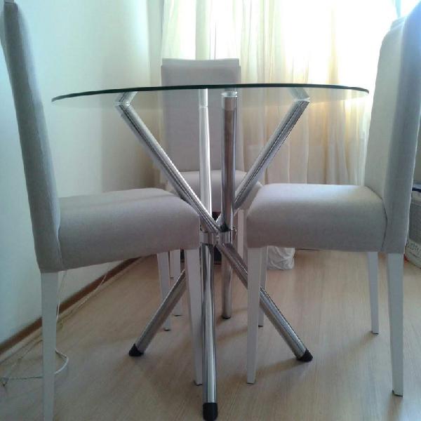 Mesa redonda de vidro com três cadeiras de madeira