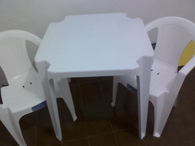 uma mesa e duas cadeiras de plastico