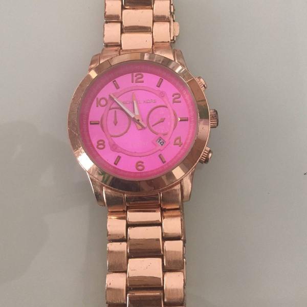 relógio dourado com fundo rosa