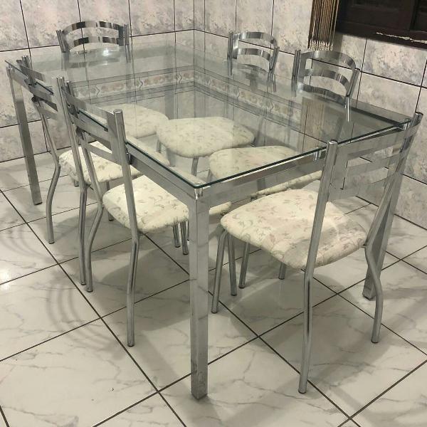 mesa de vidro e metal com seis cadeiras estofadas