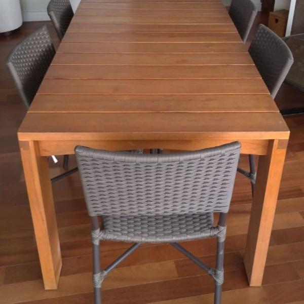 mesa de madeira com seis cadeira e duas banquetas