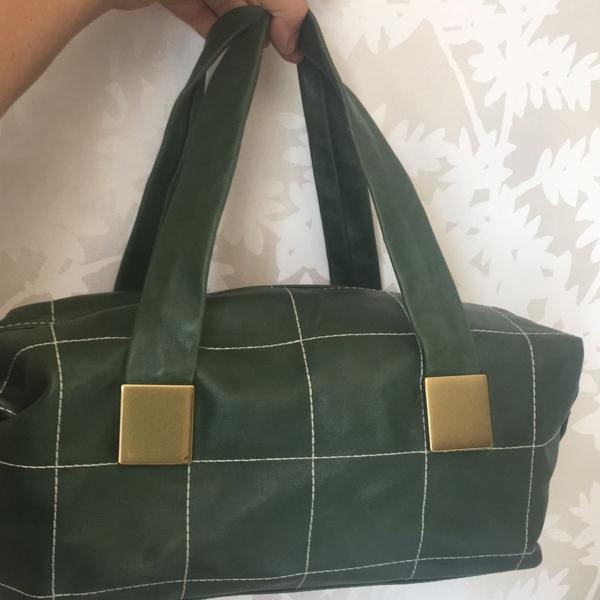 bolsa em couro verde com pespontos brancos e metais