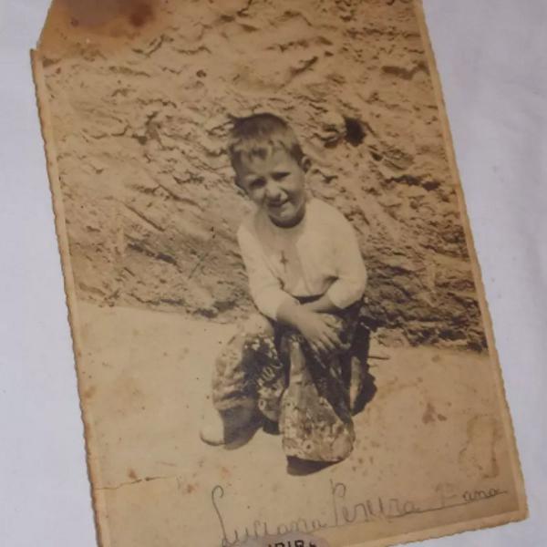 fotografia antiga menino sentado no quintal