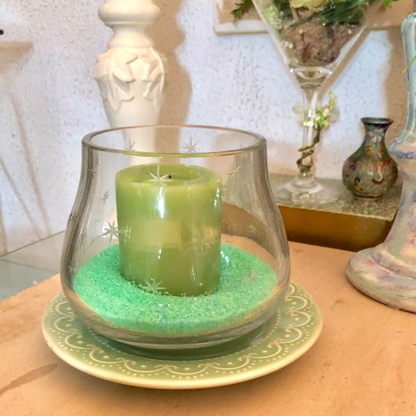 bowl de vidro antigo com vela sob areia