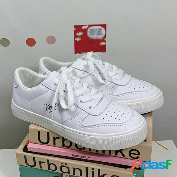 As mulheres atam sapatos de cor sólida